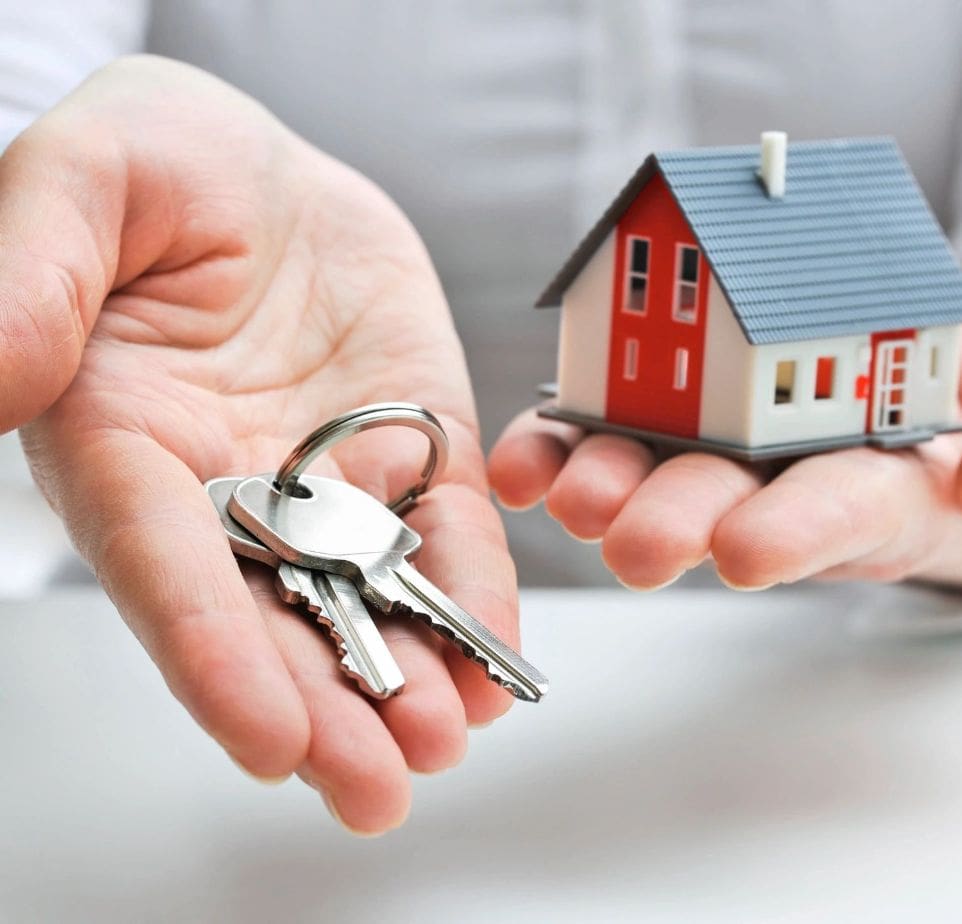 A person holding out their hands with keys in front of them.